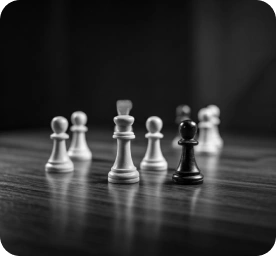Close-up van zwart-witte schaakstukken op een houten bord, dat strategisch denken, besluitvorming en klassieke tafelspellen symboliseert in een rustige clubomgeving.