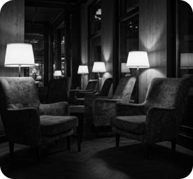 Comfortabele fauteuils met warme verlichting in een rustige lounge van de bordspelclub, die een ontspannen sociale sfeer creëert voor strategische discussies en tafelspelavonden.